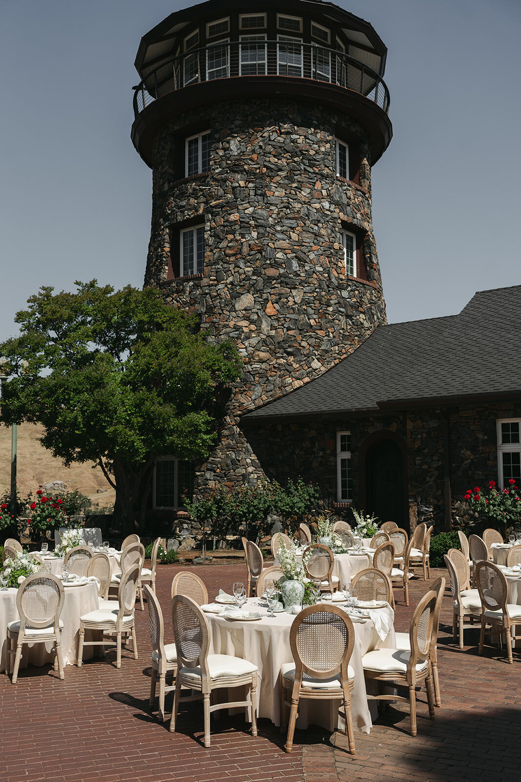 A reception of round tables set beneath the stone Tower